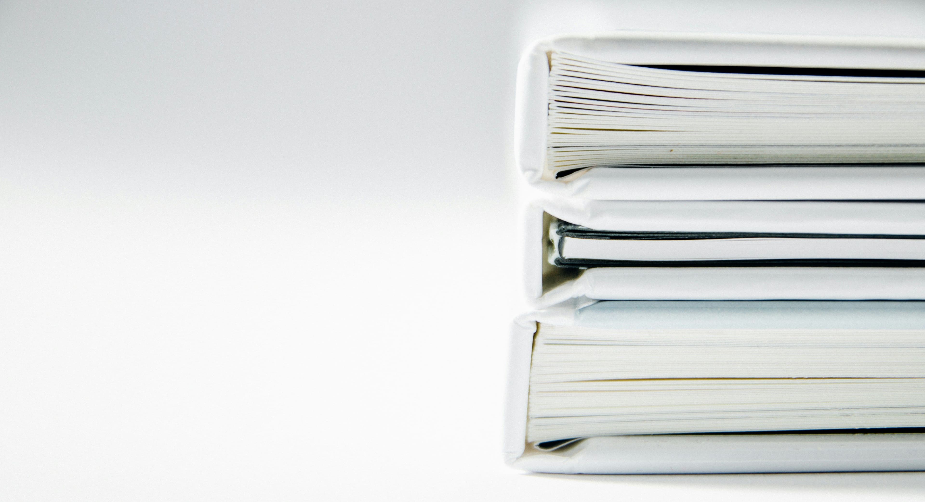 a stack of binders sitting on top of each other on a white surface .