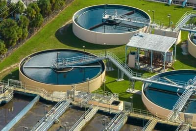an aerial view of a water treatment plant with a lot of tanks and pipes .