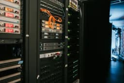 a server room filled with lots of servers and cables .