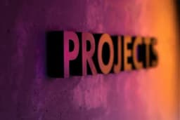 the word projects is on a purple and orange wall .